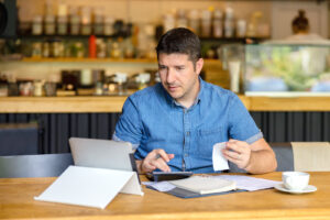 Small business owner calculating finance bills of new business start up