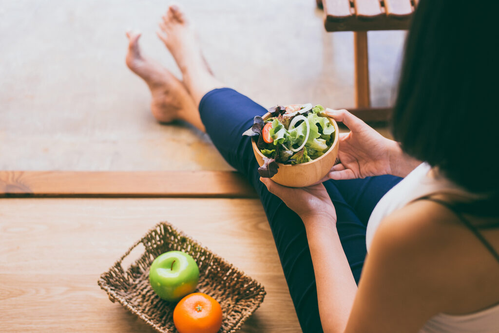 Woman holding and eating healthy salad for breakfast.