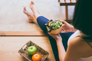 Woman holding and eating healthy salad for breakfast.