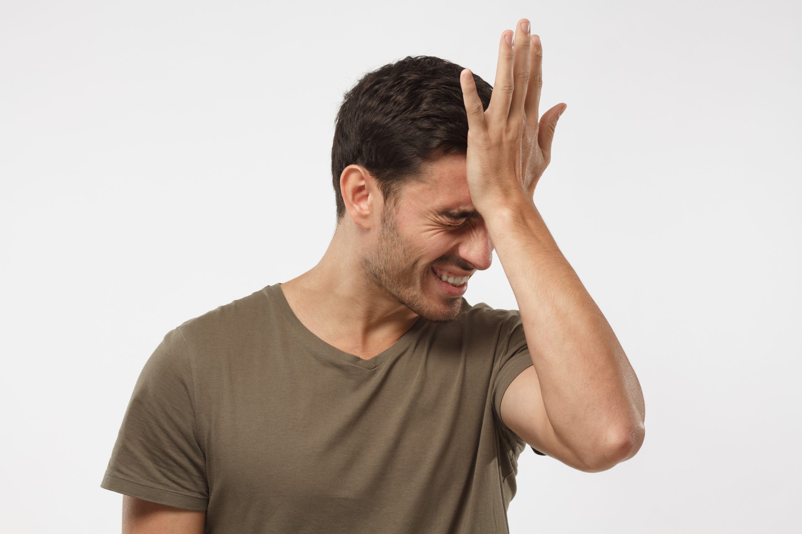 Disappointed stressed out guy making facepalm gesture with hand.