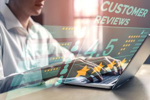 User giving a rating and writing a customer review using a laptop