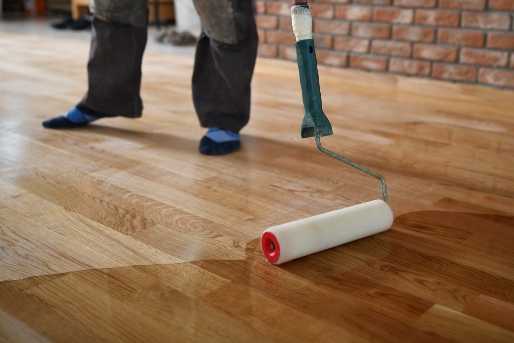 Worker lacquering wood floors