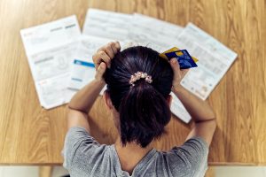 Stressed woman worrying about credit card debt and all loan bills.