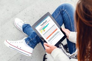 Young woman reading online reviews on her tablet